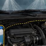 Open car hood showing the windshield washer-fluid reservoir and hood-mounted spray nozzles