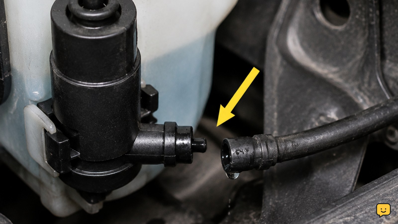Close view of a windshield washer hose connected to a reservoir pump under a car hood