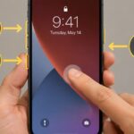 An iPhone with its lock screen awake while a hand begins the force-restart button sequence